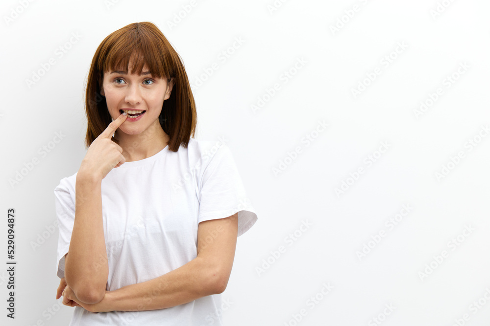 a beautiful, playful, thoughtful woman stands holding her finger near her mouth. Horizontal photo with an empty space for inserting an advertising layout a beautiful, playful, thoughtful woman stands holding her finger near her mouth. Horizontal photo with an empty space for inserting an advertising layout