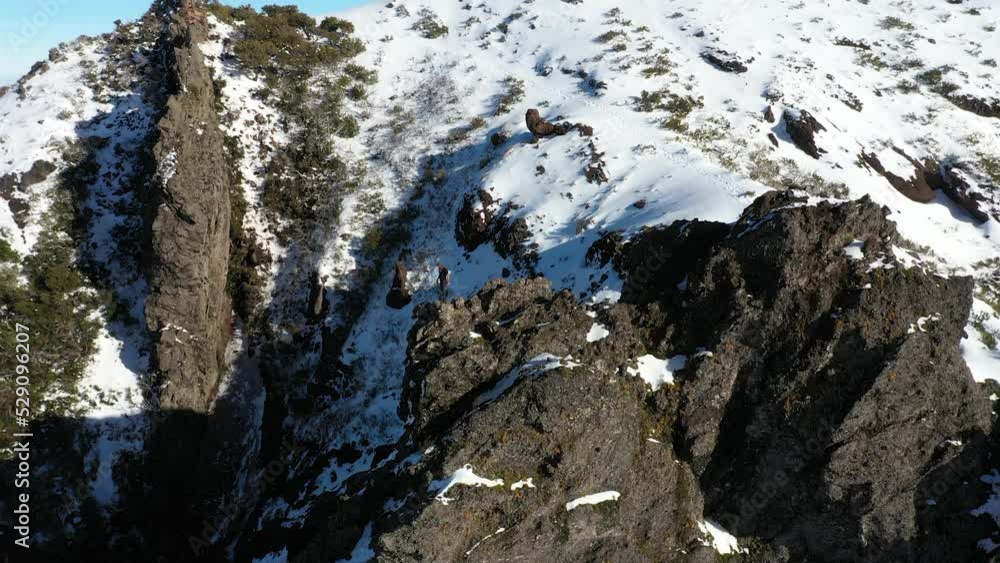 A man is walking down the very steep and dangerous cliff to the edge of the mountain Pico Ruivo in Madeira. A man is walking down the very steep and dangerous cliff to the edge of the mountain Pico Ruivo in Madeira.