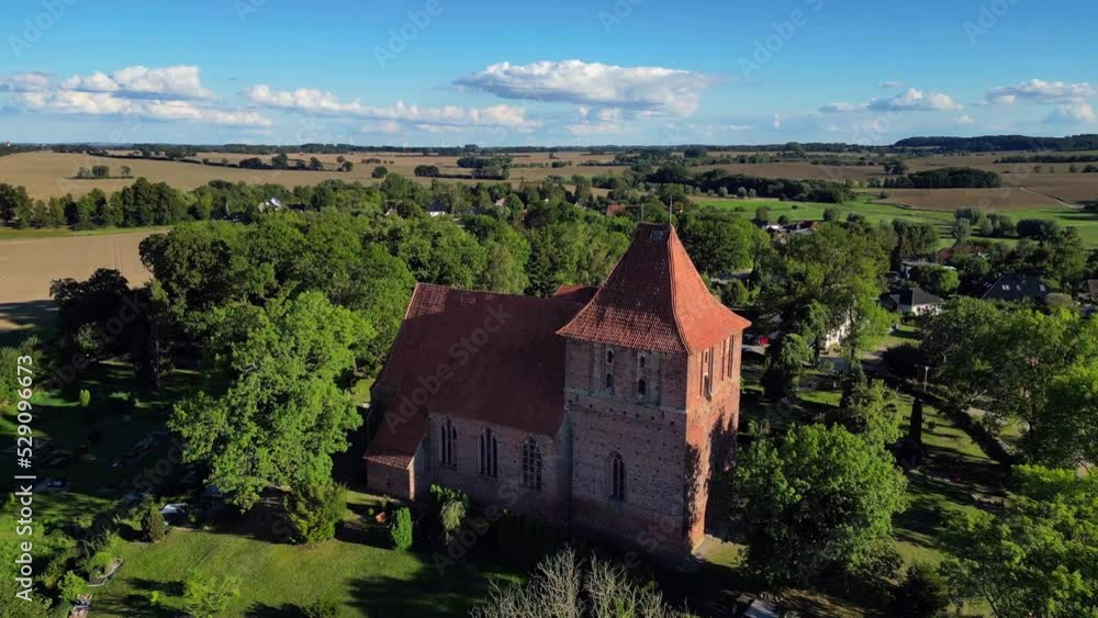 Dramatic aerial view flight point of view POV shot drone of red brick village church with cemetery in hohenkirchen germany at summer day golden hour August 2022. Marnitz 4k Cinematic from above Dramatic aerial view flight point of view POV shot drone of red brick village church with cemetery in hohenkirchen germany at summer day golden hour August 2022. Marnitz 4k Cinematic from above