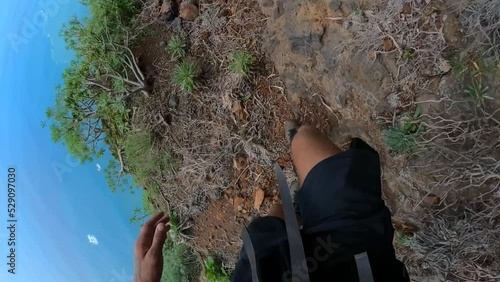 POV of an athletic man's legs and shoes, walking down the dirt trail on the edge of a mountain in Madeira.