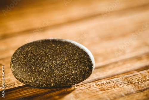Stone balanced on wooden table