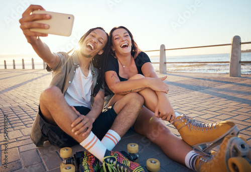 Selfie of young skater friends with phone smile and laugh at the beach. Cool cheerful man and woman smiling and having fun on the weekend. Happy couple with rollerskate having fun together outside