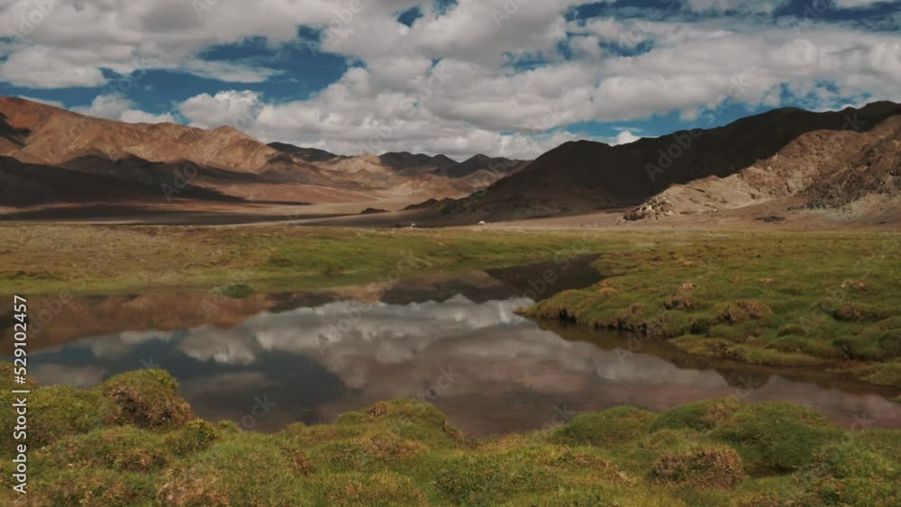 Aerial view of a valley with a small pond and mountain in background, Ladakh region, India. Aerial view of a valley with a small pond and mountain in background, Ladakh region, India.