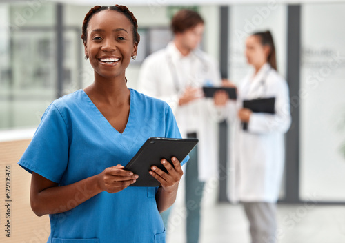 Portrait of happy woman doctor working on a digital tablet and smile while working at a hospital. Black female nurse doing medical and healthcare research on the internet or online at work at clinic