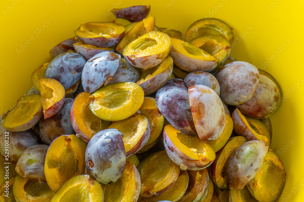 Plums harvest.Plum halves background.Yellow pulp of fruits in a yellow cup. Juicy pulp texture.Farm organic bio fruits.Plums harvest. Plums harvest.Plum halves background.Yellow pulp of fruits in a yellow cup. Juicy pulp texture.Farm organic bio fruits.Plums harvest.