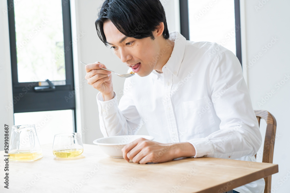 自宅でシリアルを食べる健康的な日本人男性
