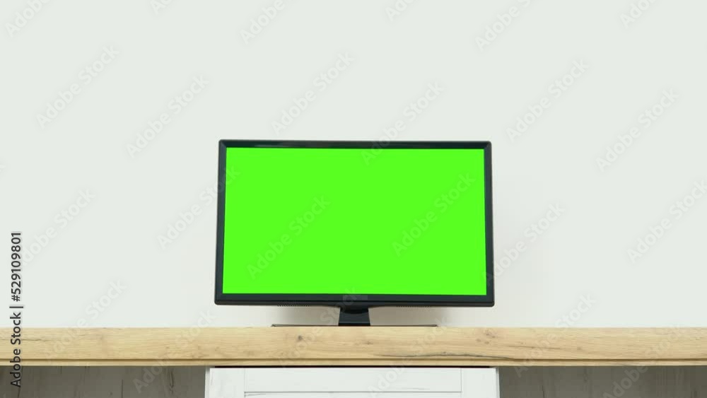 Chroma key screen for advertising. LcD smart TV screen with a blank green background in the living room Chroma key screen for advertising. LcD smart TV screen with a blank green background in the living room