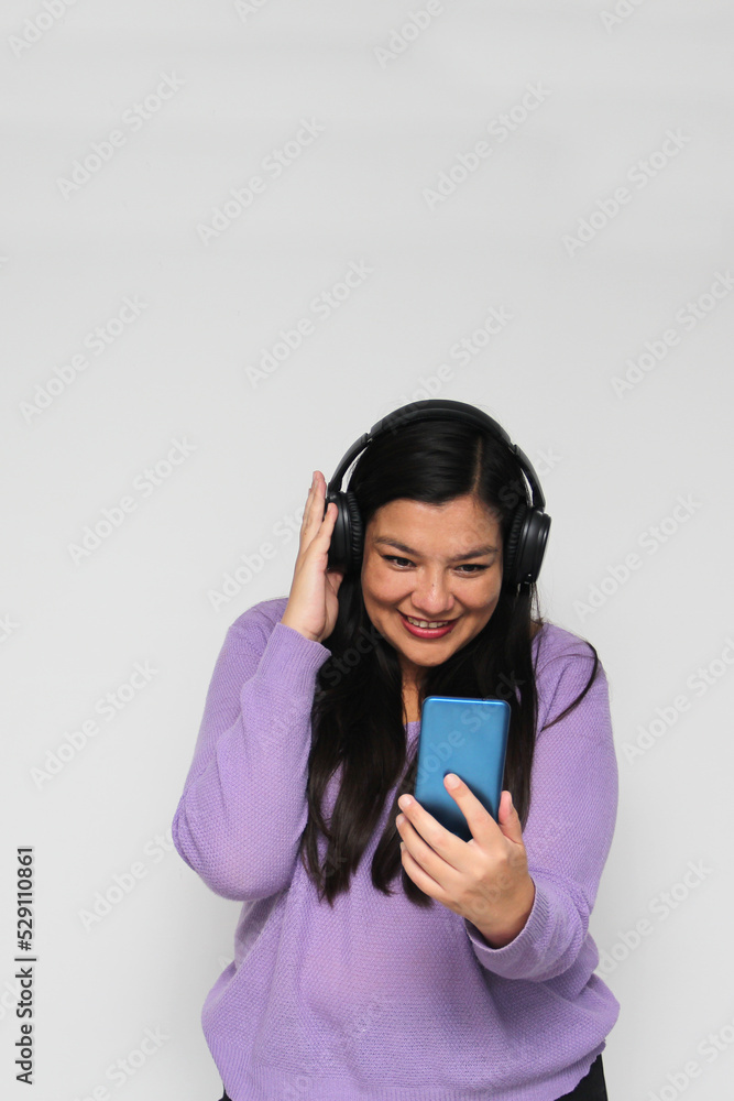 Latino adult woman uses technology with his cell phone and headphones to listen to music, play video games, make video calls, watch series, shopping and date on the app
Latino adult woman uses technology with his cell phone and headphones to listen to music, play video games, make video calls, watch series, shopping and date on the app