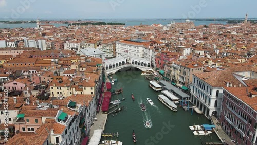 Aerial shot of boats moving under the renowned Ponte di Rialto in venice italy photo