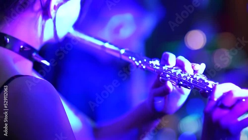 rock musician a girl plays a wind instrument, clarinet or flute on the stage of a rock concert