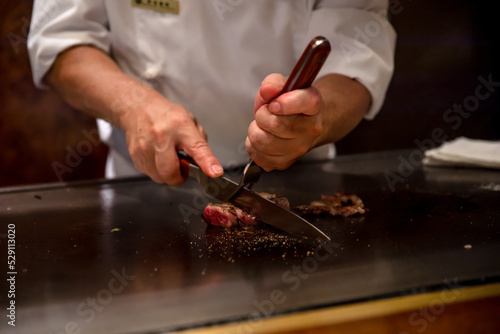 鉄板焼きステーキを料理人が調理している photo