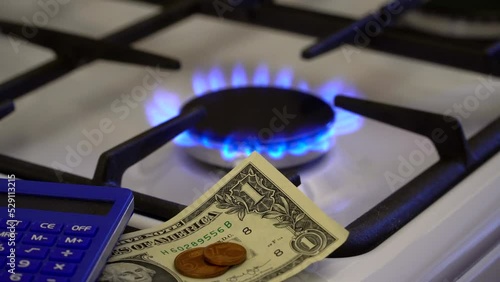 Shortage and gas crisis. Money and a calculator on the background of a burning gas stove