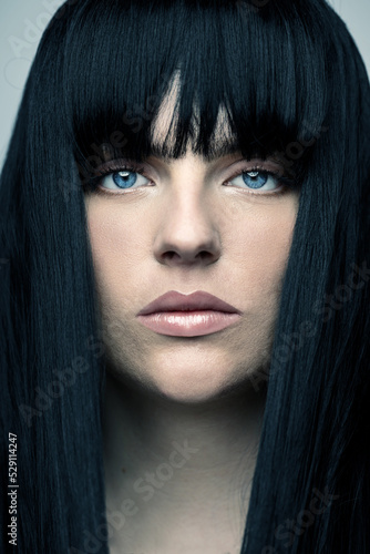 Fototapeta Naklejka Na Ścianę i Meble -  Fashion and make-up concept. Beautiful woman with bob haircut long dark hair close-up studio portrait. Model with pink lipstick and clean skin looking at camera. Toned image with blue color