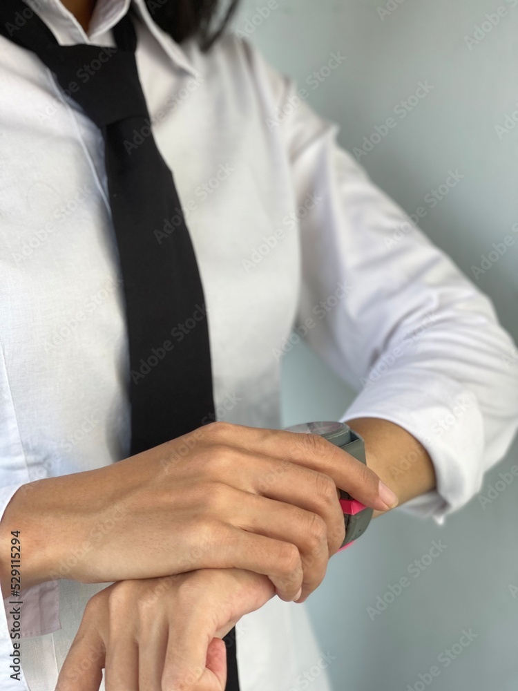 A worker is looking at the watch on the wrist. A worker is looking at the watch on the wrist.