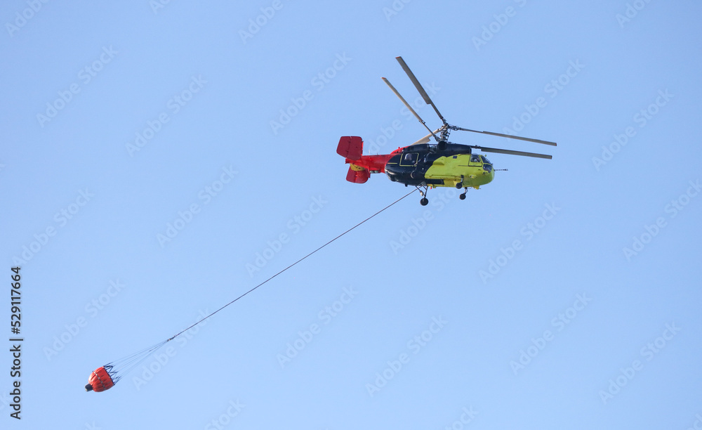 Helicopter with water to extinguish a fire Helicopter with water to extinguish a fire