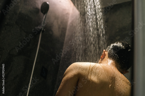 asian young man is taking shower in the bathroom