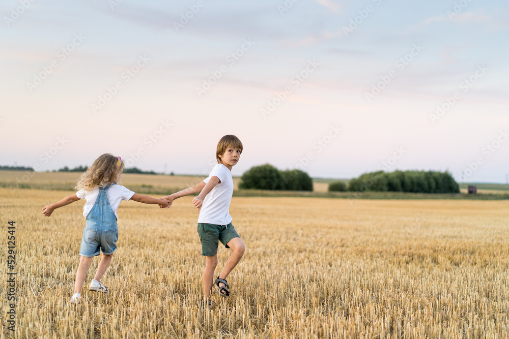 Happy and free people, children run through the beveled field of wheat Happy and free people, children run through the beveled field of wheat