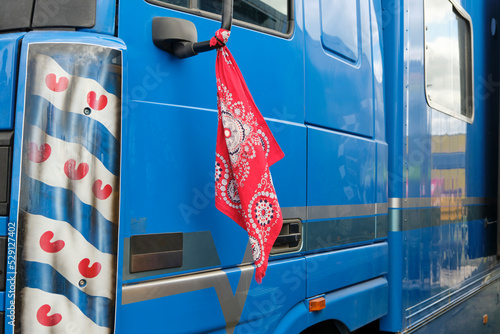 Red farmer handkerchief as a farmers protests symbol in The Netherlands attached to a blue truck. Farmers in the Netherlands protesting against forced shrinking of livestock because of CO2 emissions.  photo