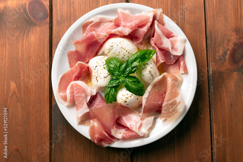 Foto Piatto con prosciutto e mozzarella di bufala, deliziosi antipasti italiani