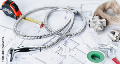 Plumbing project in house.Drawing,diagrams,plan of water supply of apartment,building.Man repairer making repairs at home.Devices,accessories, hose,tap,adjustable wrench,pressure reducer,tape measure
