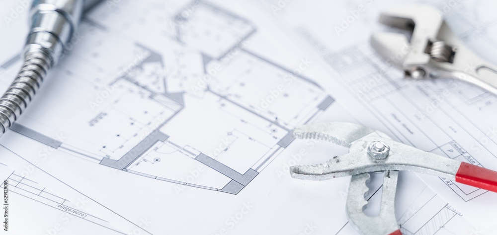 Plumbing project in house.Drawing,diagrams,plan of water supply of apartment,building.Man repairer making repairs at home.Devices,accessories, hose,tap,adjustable wrench,pressure reducer,tape measure Plumbing project in house.Drawing,diagrams,plan of water supply of apartment,building.Man repairer making repairs at home.Devices,accessories, hose,tap,adjustable wrench,pressure reducer,tape measure