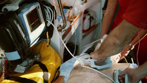 Medical team using defibrillator on the patient in ambulance car