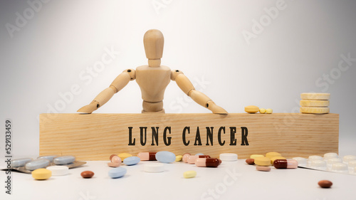 Lung cancer. Written on wooden surface. Wooden man and medicine concept.