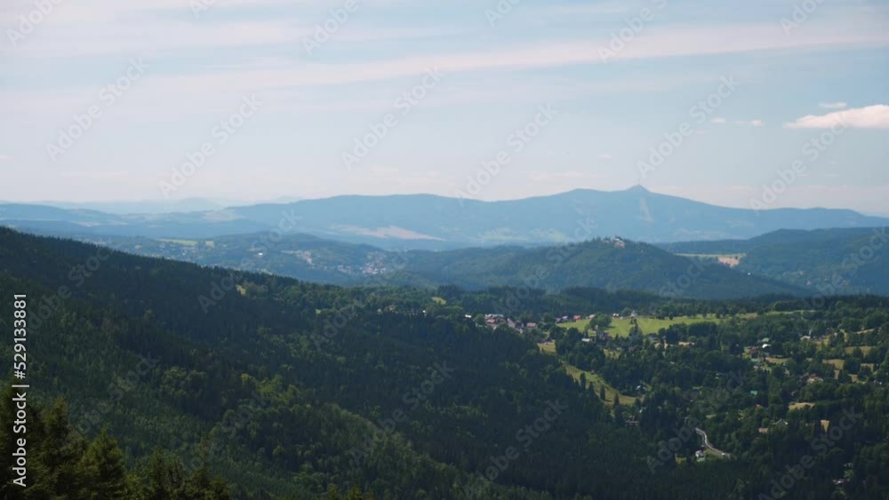 A panning shot of a beautiful view of the Karkonosze mountains in morning with blue sky having golden clouds background A panning shot of a beautiful view of the Karkonosze mountains in morning with blue sky having golden clouds background
