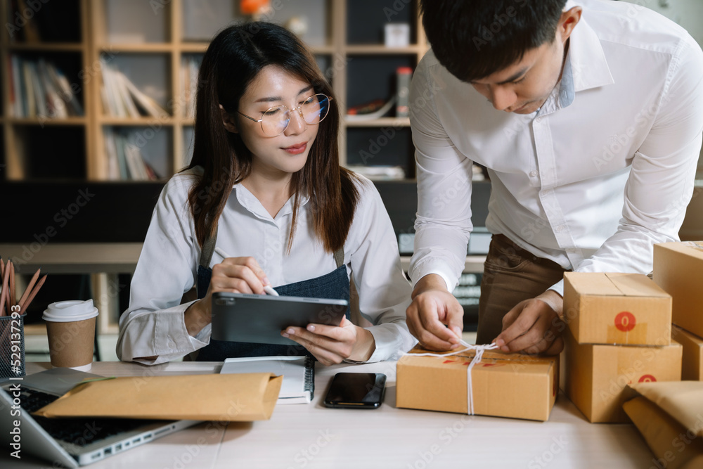Perspectives of female and male online shops, small businesses, business owners, entrepreneurs. Packing postal packages, parcel delivery boxes, preparing parcels on the table. Perspectives of female and male online shops, small businesses, business owners, entrepreneurs. Packing postal packages, parcel delivery boxes, preparing parcels on the table.