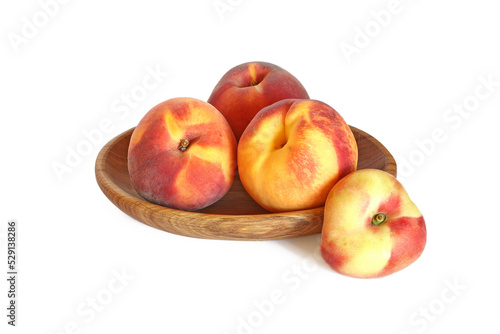 Tasty peaches in wood bowl isolated on white