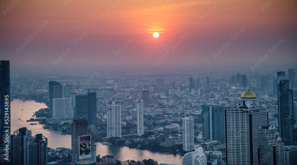 View of big city with river and sun set.