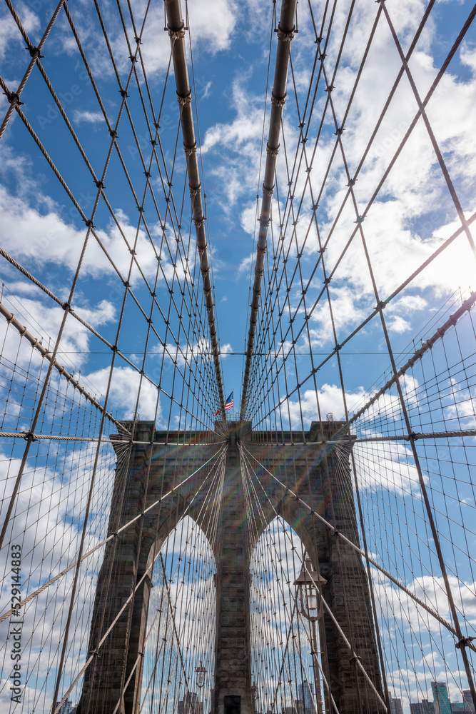 Obraz premium Symmetrical shot of the Brooklyn Bridge with beautiful clouds and blue sky
