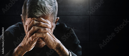 Asian senior man covering his face with his hands. Depression and anxiety Copy space..