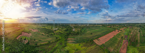 Aerial panorama view of countryside with windmills, Agriculture fields and different variety of harvest, Panaramic view of forest with sunset sky, Twilight sky and cloudscape. clean energy concept