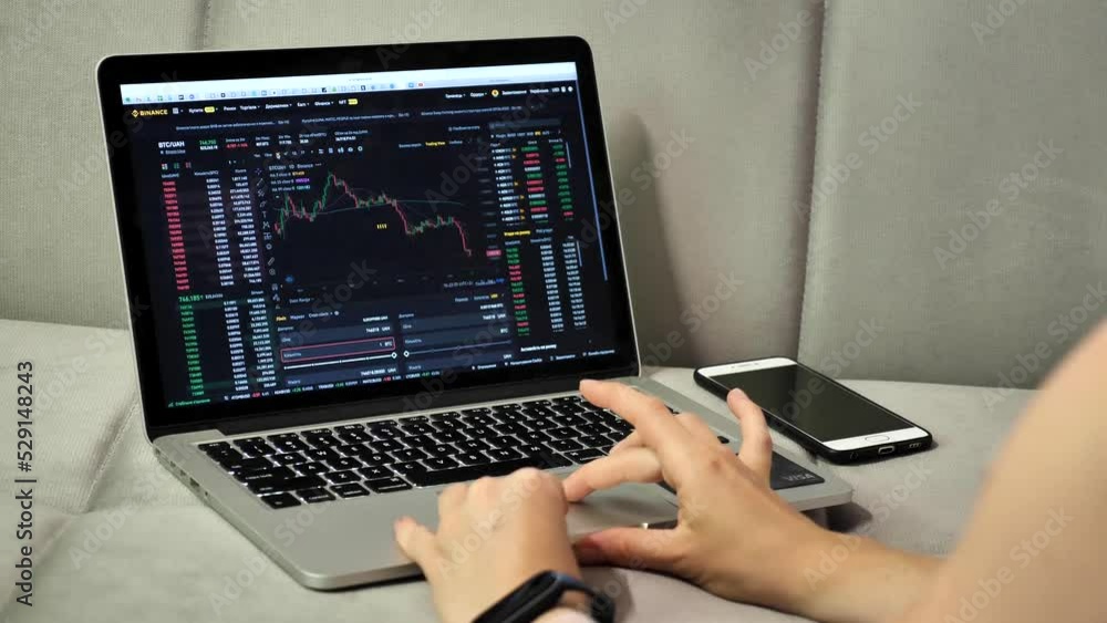 Laptop and phone to buy bitcoin on the Binance crypto exchange during the market crash. Trading, spot, staking. Workspace freelance flatlay