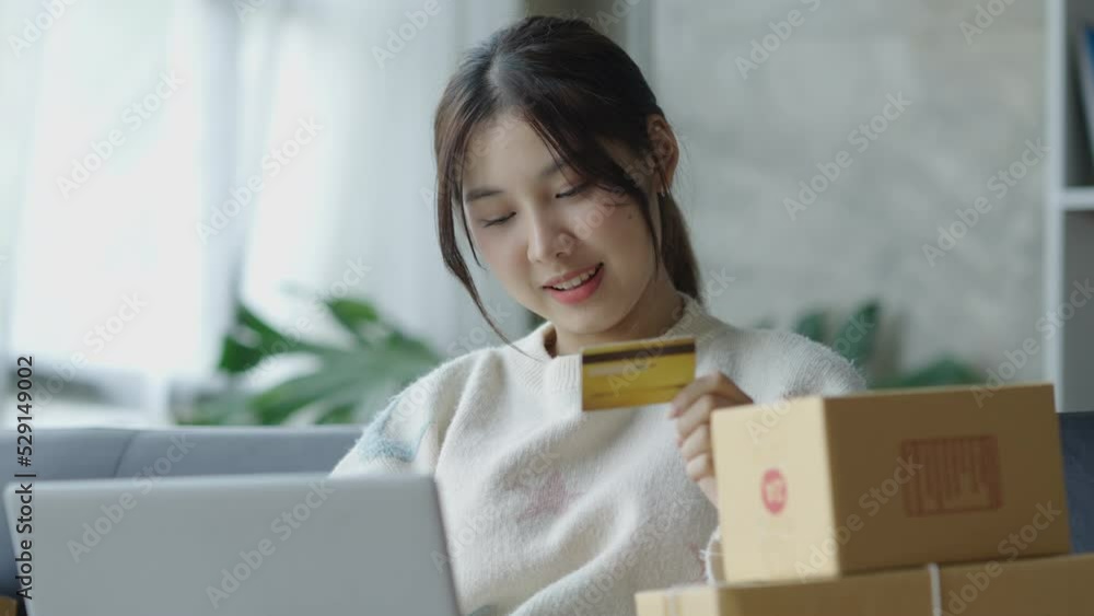 Young Asian woman using laptop to check balance and online shopping enjoy online shopping using credit card. Young Asian woman using laptop to check balance and online shopping enjoy online shopping using credit card.