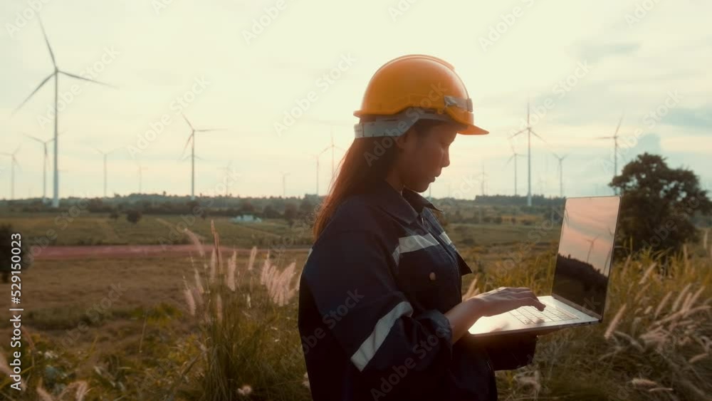 a woman engineer is wearing a protective helmet on her head, using computer Analytics engineering data..