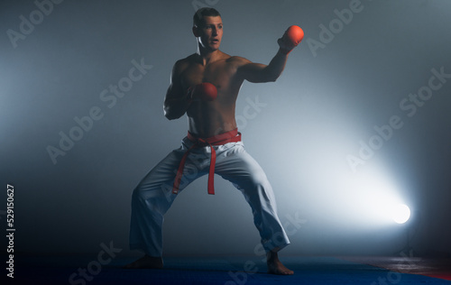 Young black belt fighter training karate in gym