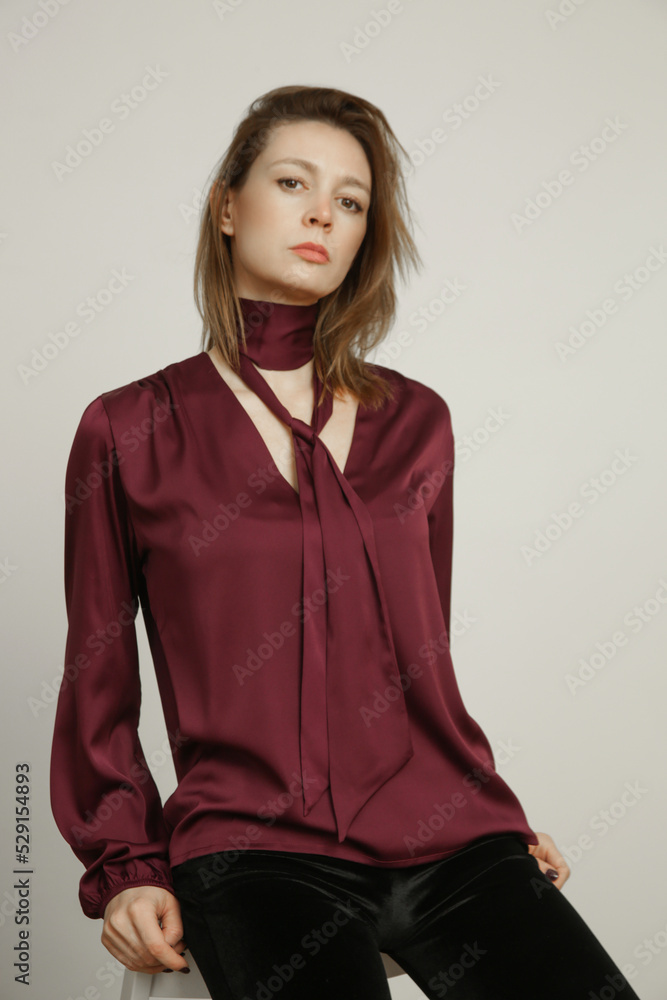 Serie of studio photos portrait of young female model in silk satin burgundy blouse Serie of studio photos portrait of young female model in silk satin burgundy blouse