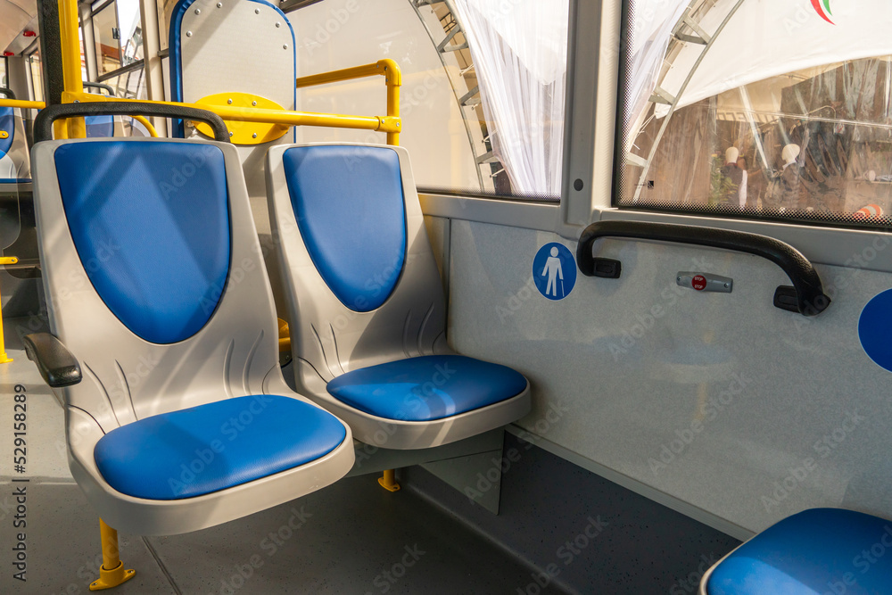 Obraz premium New comfortable seats inside a modern public bus. Seats on the bus for the elderly, people with disabilities and passengers with children. Special seats for certain categories of passengers.