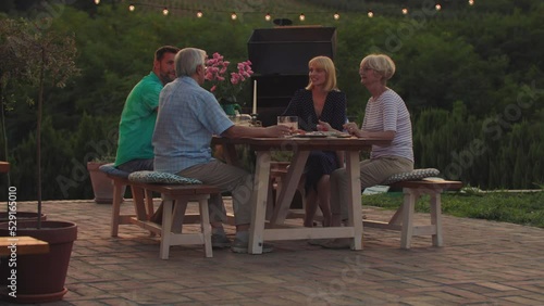 Affectionate family enjoying dinner while their get together in the backyard