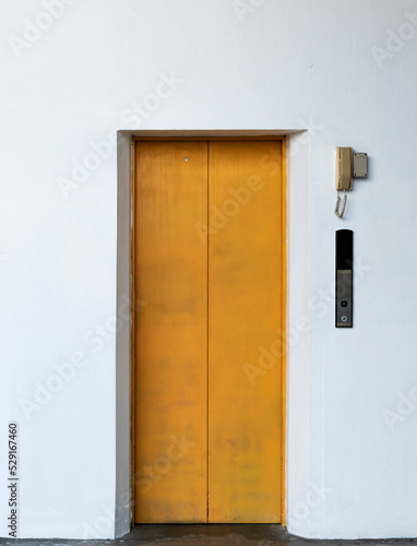 Yellow lift closed door with white wall background © Ratchapon