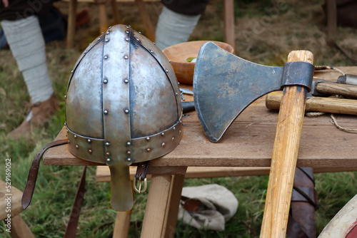 A Norman style helmet set upon a bench with a long handled axe.