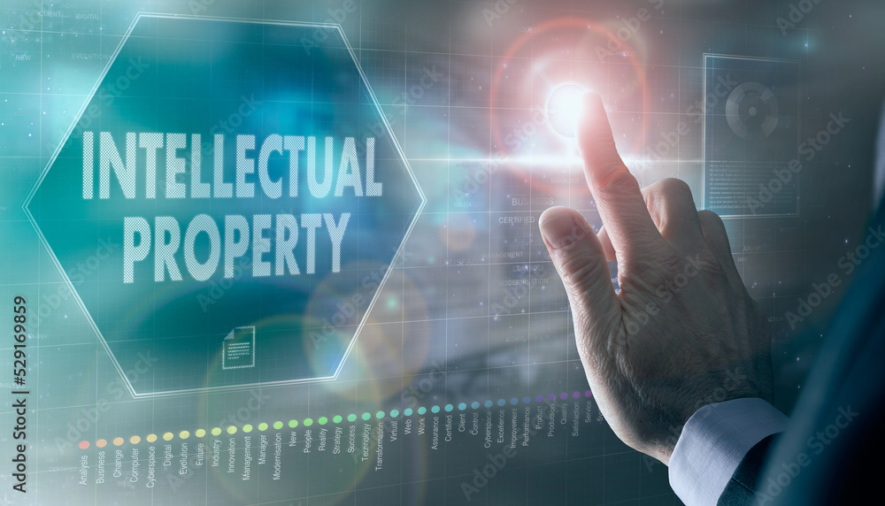 A businessman controlling a futuristic display with a Intellectual Property business concept on it.
