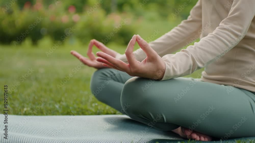 Woman practices yoga and meditates in lotus position. Healthy female girl sits in pose of lotus meditating or practicing yoga in nature. Meditation practices. Yoga healthcare concept. Woman practices yoga and meditates in lotus position. Healthy female girl sits in pose of lotus meditating or practicing yoga in nature. Meditation practices. Yoga healthcare concept.