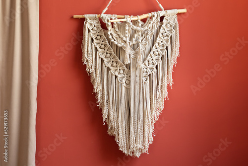 Wall panel in style of Boho made of cotton threads using the macrame technique for home decor and wedding decoration. Cozy Home decor concept. White Macrame in living room with boho interior design	