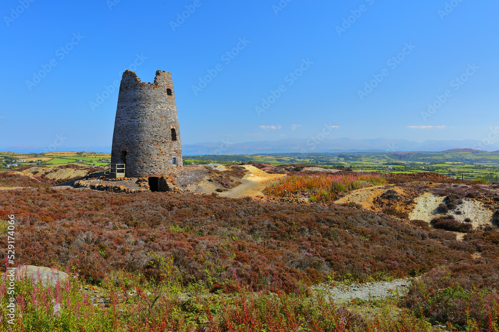 Disused Windmill at Parys Mountain with Snowdonia in the distance. Anglesey, North Wales, UK.