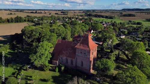 House of God, believeButtery soft aerial view flight panorama overview droneof red brick village church in hohenkirchen germany at summer day golden hour August 2022 photo