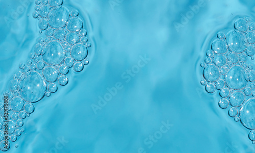 Cosmetic texture. Gorgeous structure of cosmetic gel bubbles on blue background with central copy space