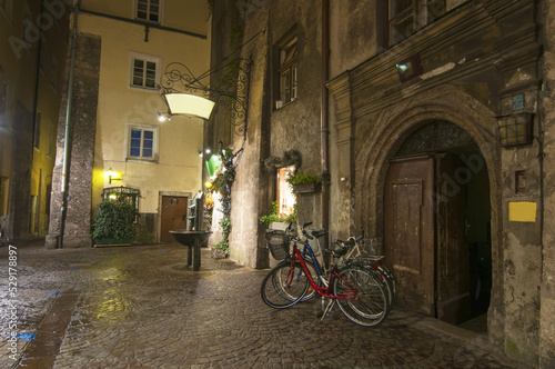 Bicycles parked on empty medieval street in old city of Innsbruck at night, Tirol, Austria